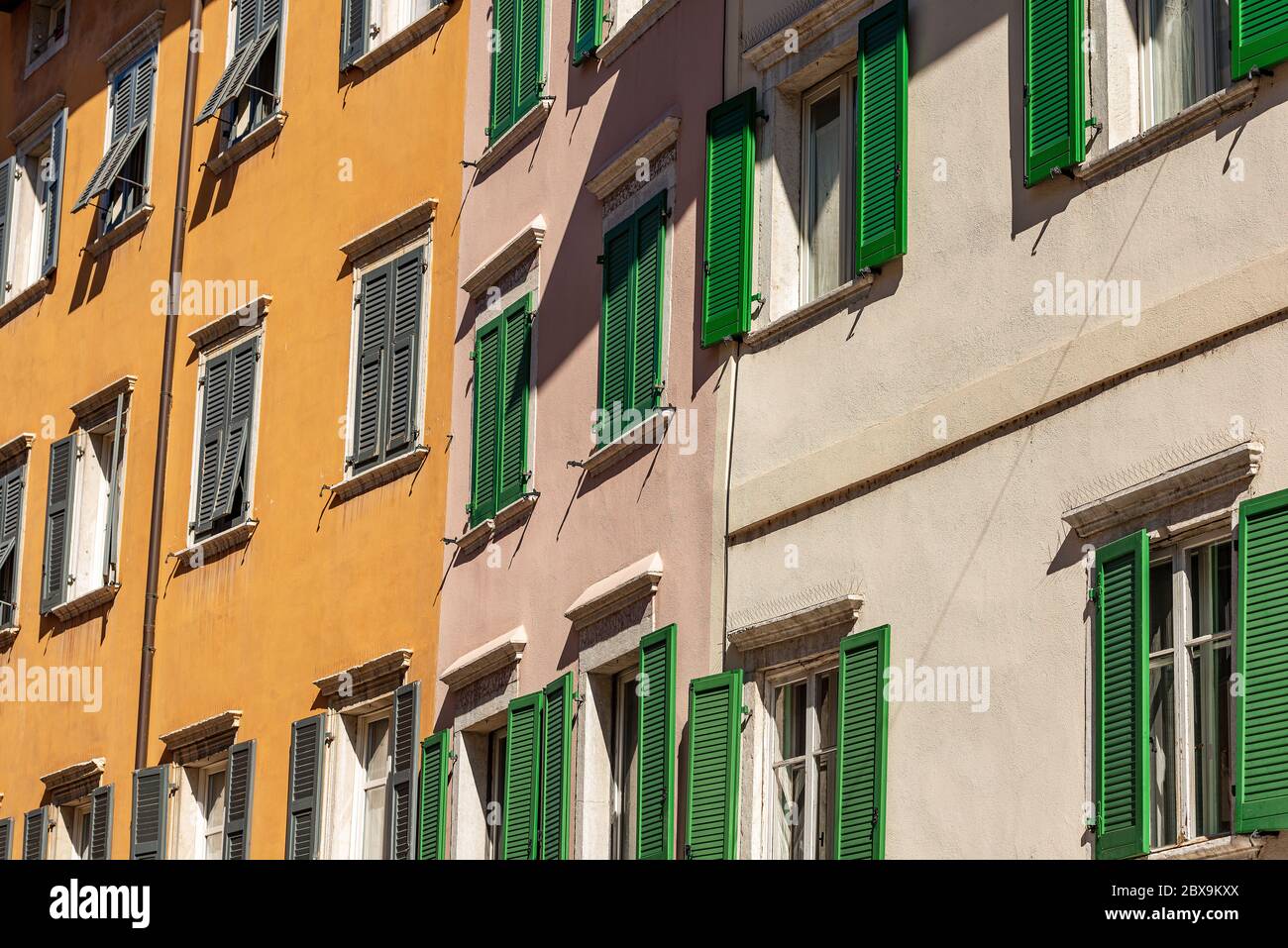 Fassade von generischen Häusern mit vielen Fenstern und Fensterläden in einer Straße in Trentino-Südtirol, Italien, Europa Stockfoto