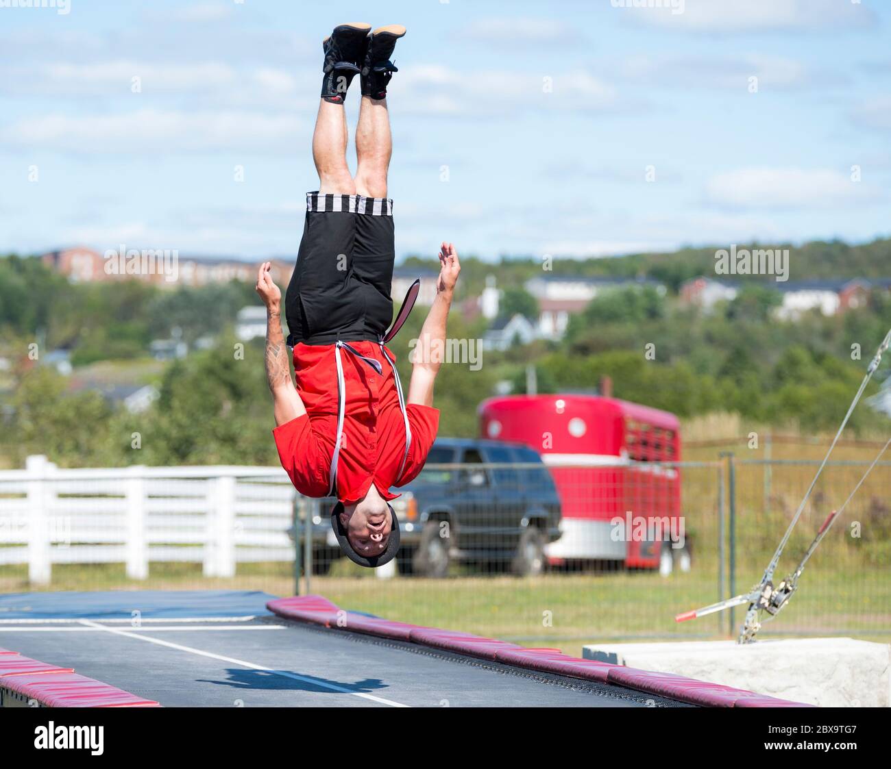 Saint John, New Brunswick, Kanada - 4. September 2015: Ein akrobat spielt auf der Saint John Ausstellung. Er steht auf dem Kopf über einem langen Trampolin. Stockfoto