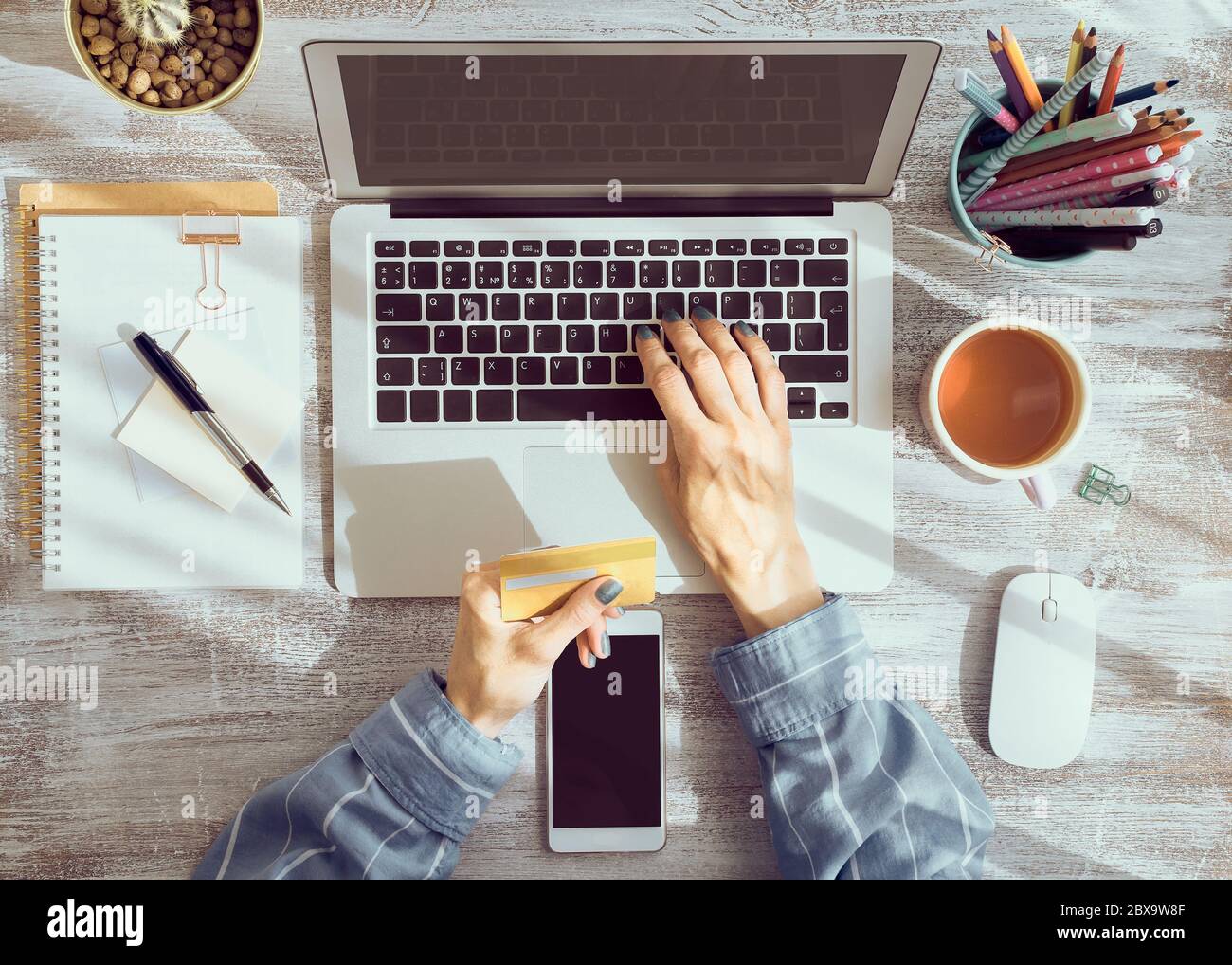 Online-Shopping-Konzept. Unkenntlich Frau, die Tee trinkt und Laptop anschaut Stockfoto