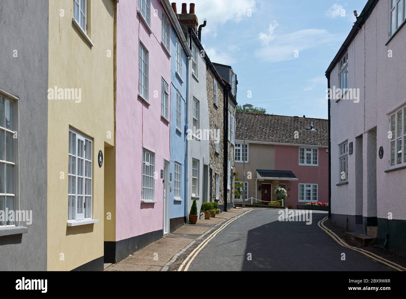 Eine Straße in Lyme Regis, Dorset mit pastellfarbenen Häusern und kein Verkehr. Teil des East Devon Way, des Liberty Trail und des Wessex Ridgeway Stockfoto