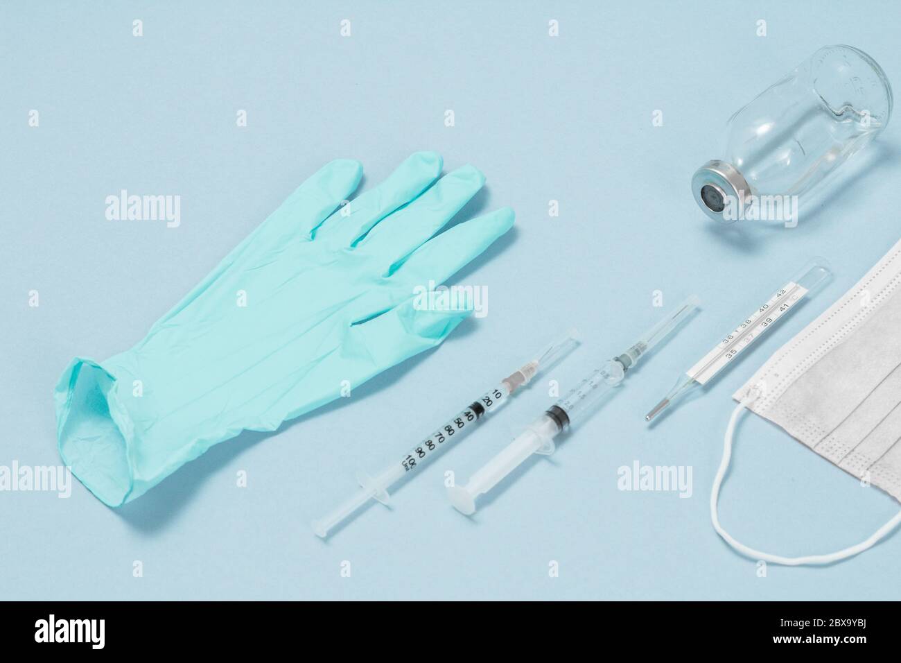 Nitril Einweg-Handschuh, eine medizinische Maske, Spritzen für Injektionen, ein Glas Quecksilberthermometer und eine Schutzbrille für den persönlichen Schutz. Draufsicht. Stockfoto