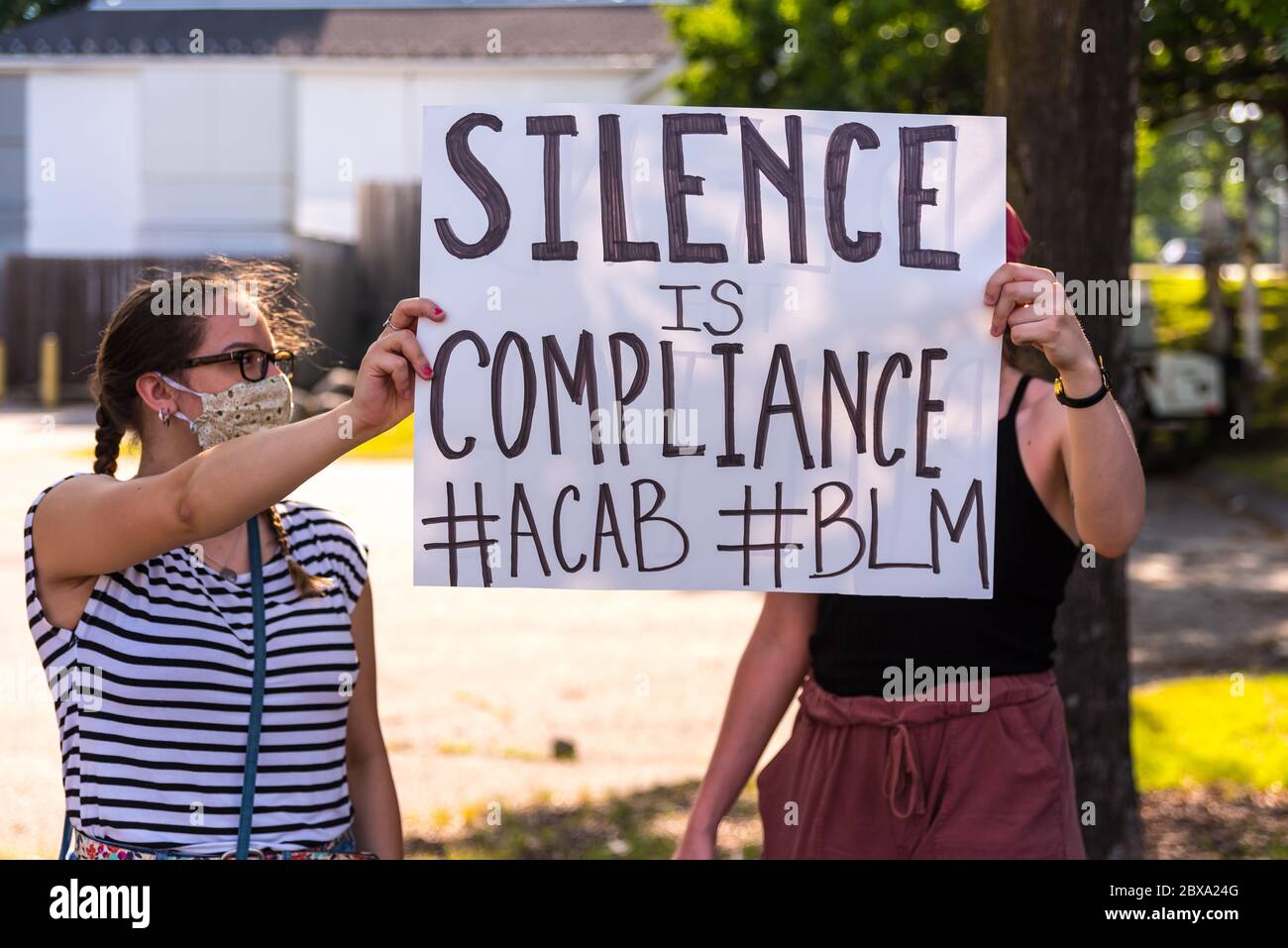 Acton, Massachusetts. Juni 2020. Junge Erwachsene stehen an der Ecke, halten selbstgemachte Schilder und protestieren zur Unterstützung der Black Lives Matter Stockfoto