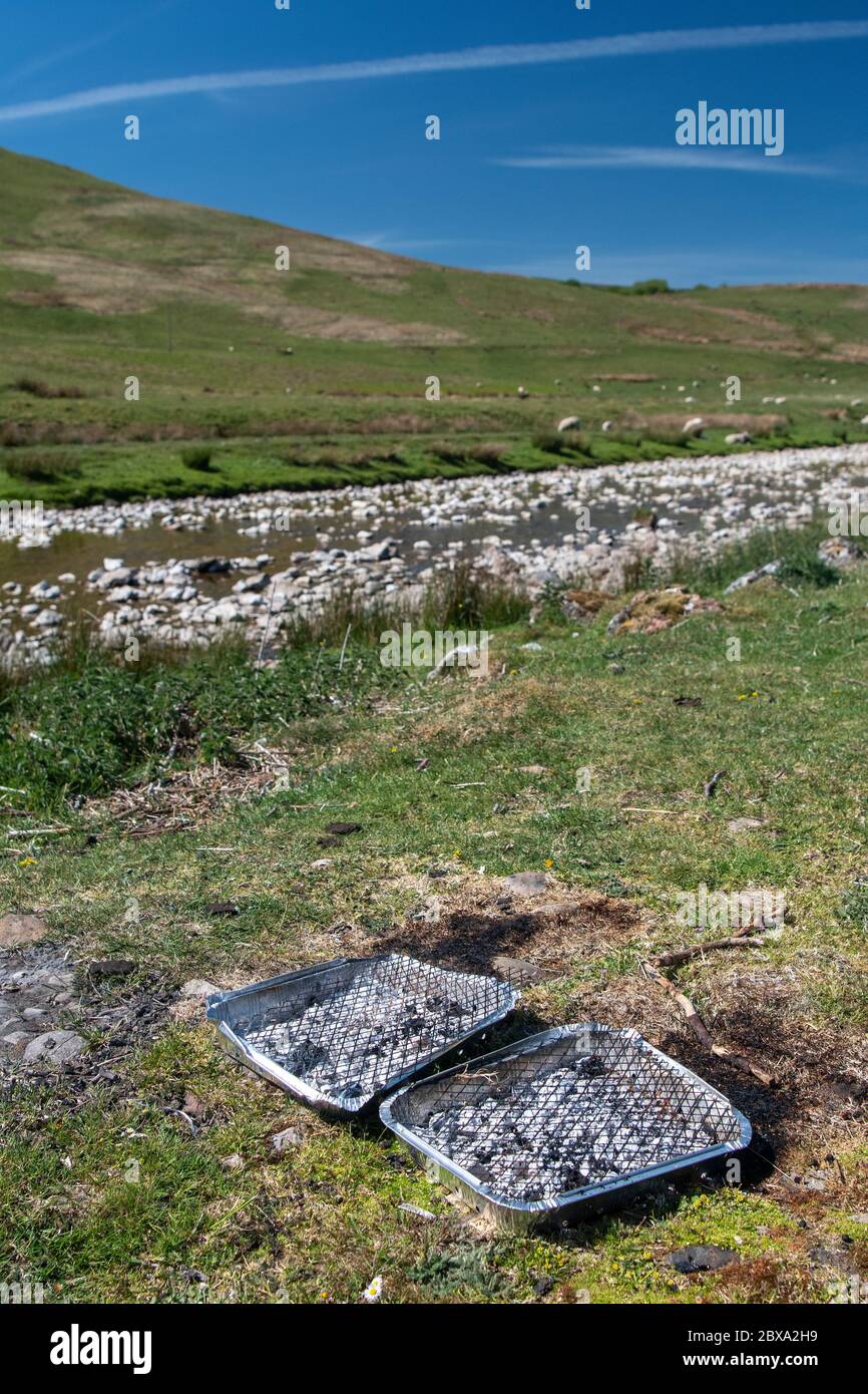 Müll nach einem BBQ in einem ländlichen Beauty-Spot am Ufer des Flusses Eden, Mallerstang, in der Nähe von Kirkby Stephen, Cumbria, Großbritannien. Stockfoto