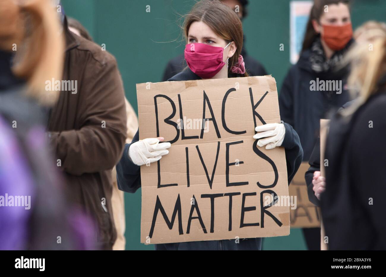 Eine junge weiße Frau, die auf einer Protestkundgebung gegen Rassismus in Großbritannien demonstriert und ein Schild mit der Aufschrift "Black Lives Matter" hält. Juni 2020. Stockfoto