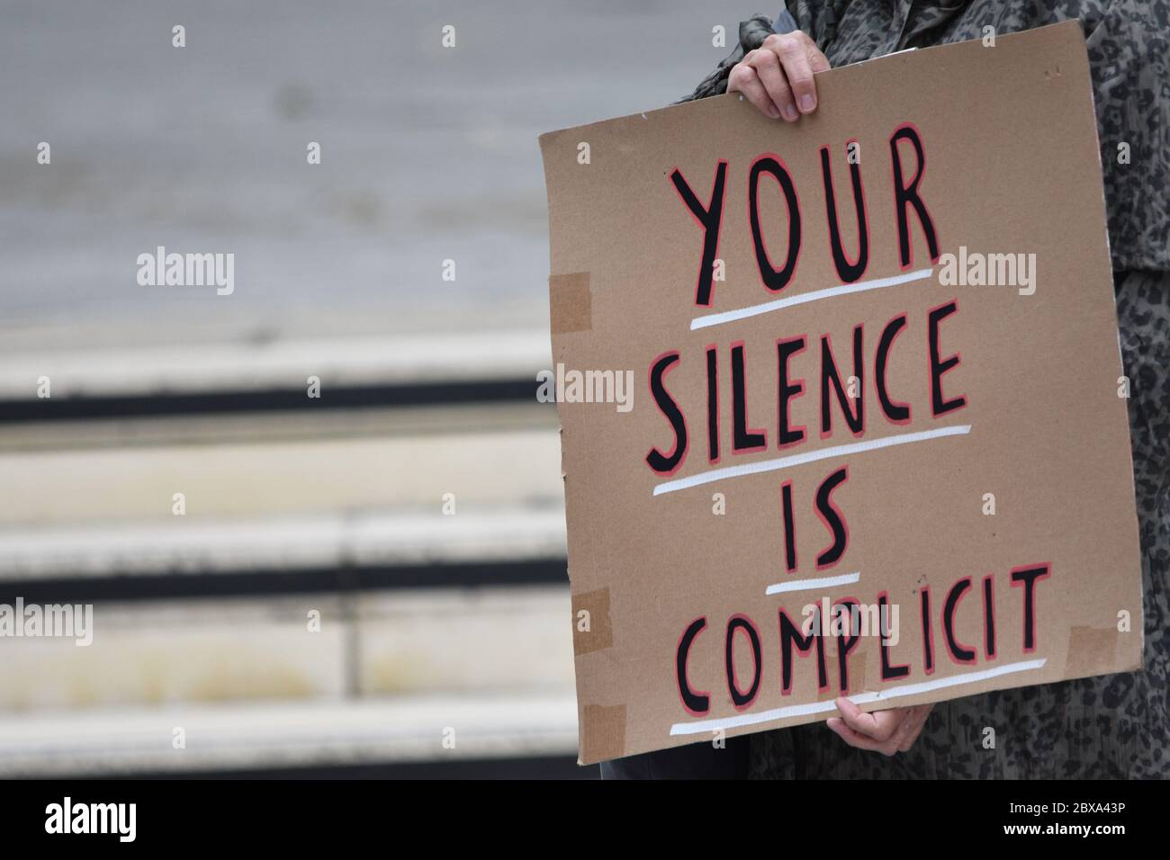 Ein Banner mit der Aufschrift „Ihr Schweigen ist Mitschuld“ auf einer britischen Protestdemonstration von Black Lives Matter im Vereinigten Königreich im Jahr 2020 Stockfoto