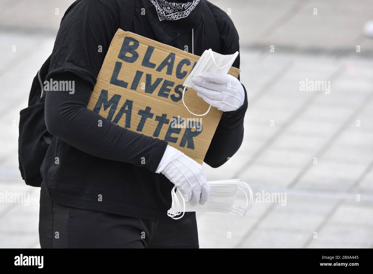 Ein Protestler, der Gesichtsmasken an andere Demonstranten bei einer Demonstration von Black Lives Matter im Vereinigten Königreich im Jahr 2020 während der Covid-Sperre verteilte Stockfoto