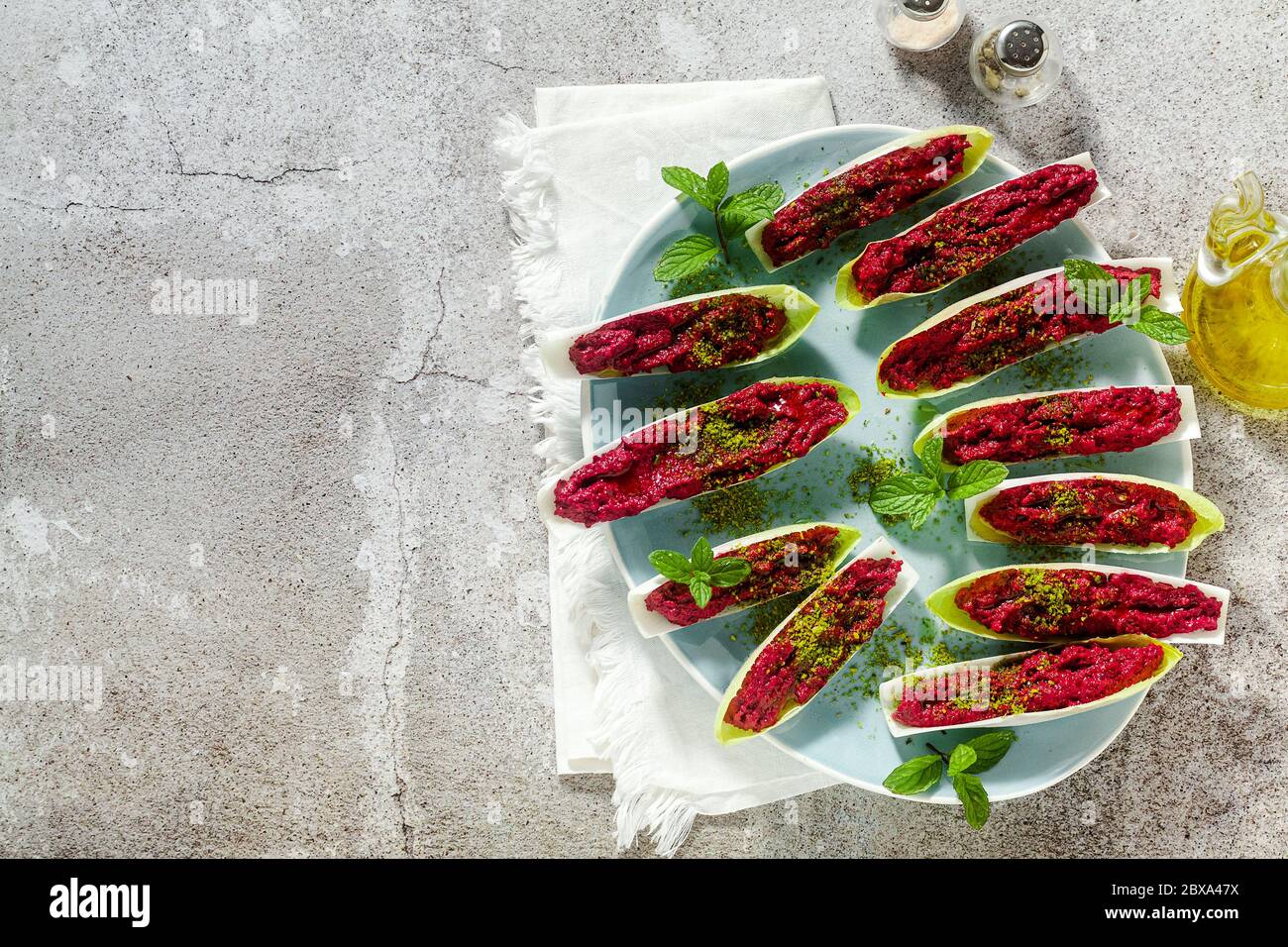 Dip von gekochten Rüben und Pistazien in Blättern von belgischen Endive mit Minze. Gesunde Sommer Snack Stockfoto