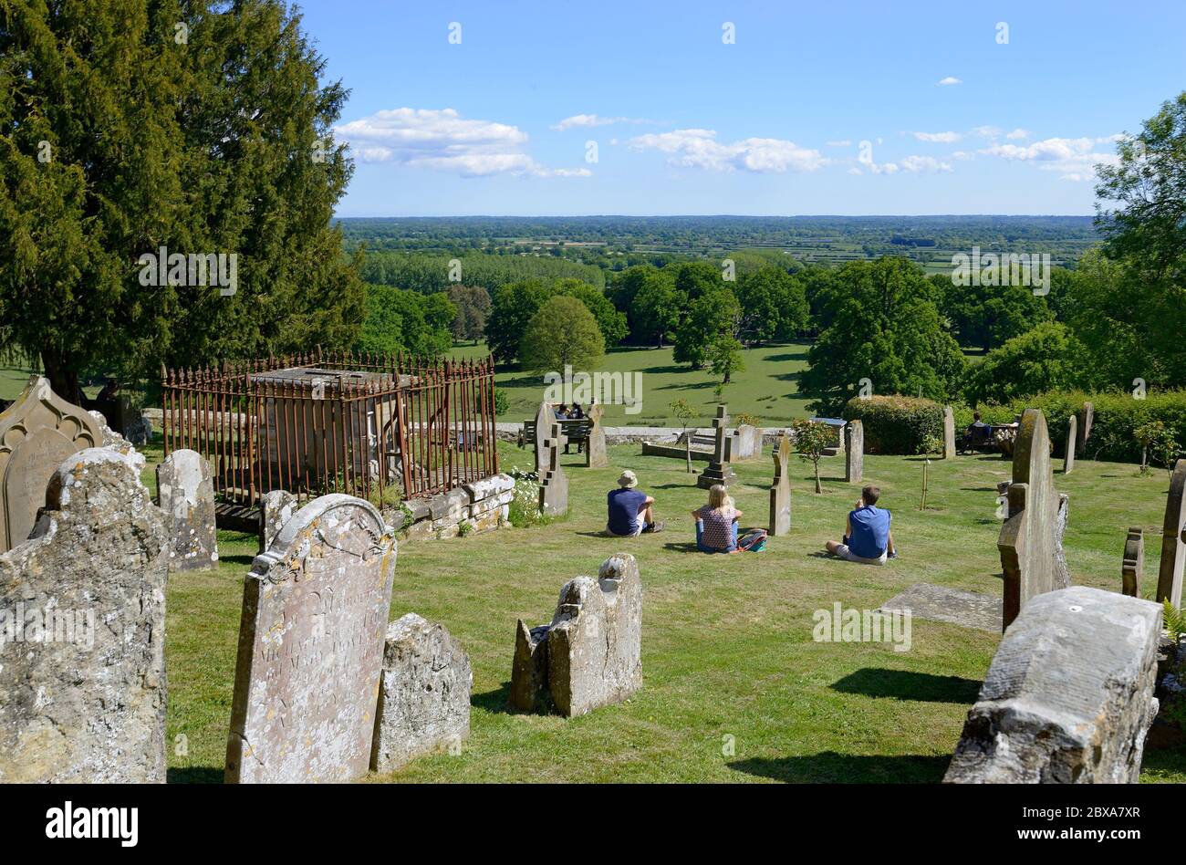 Boughton Monchelsea Village, Kent, Großbritannien. St. Peter's Church Friedhof und der Blick über den Weald of Kent. Ein paar Leute besuchen den Kirchhof practicin Stockfoto
