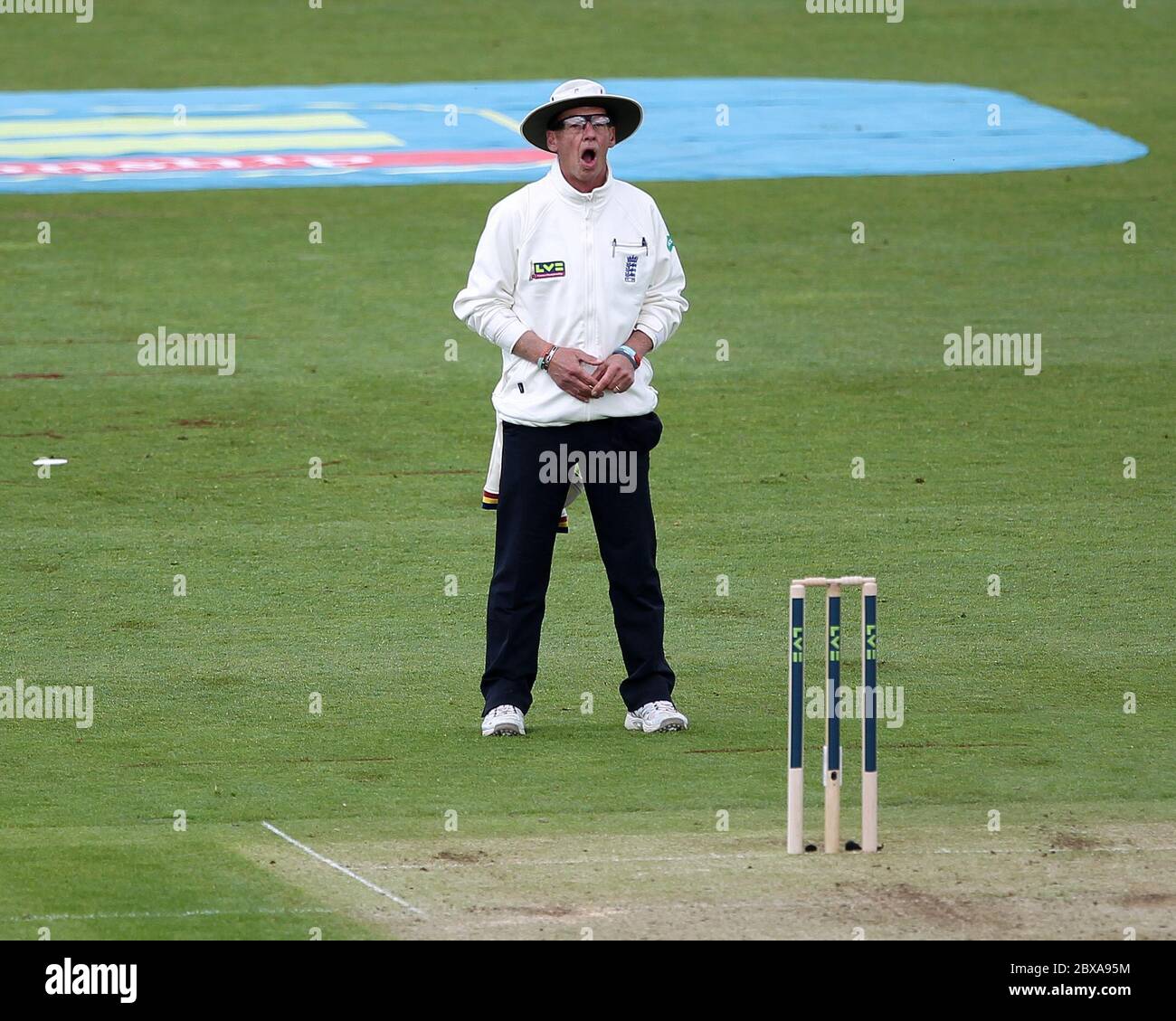 CHESTER LE STREET, ENGLAND - Umpire Jeremy Lloyds gähnt während des County Championship-Spiels zwischen Durham und Yorkshire im Emirates Riverside, Chester le Street, County Durham am Sonntag, den 4. Mai 2014. Stockfoto