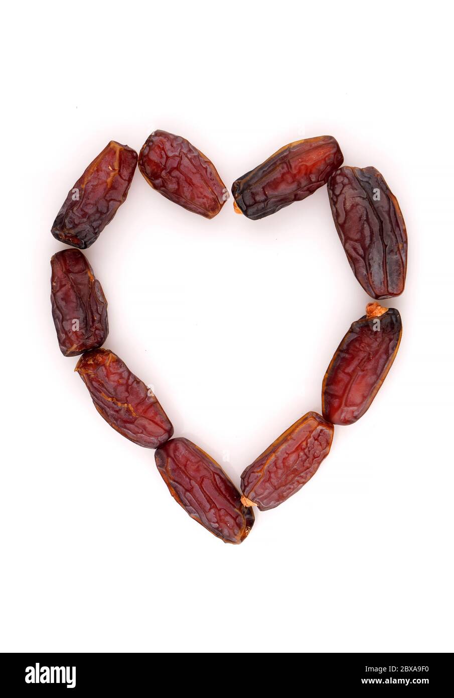 Leckere Bio-TrockenDatteln in Form von Herz. Isoliert auf weißem Hintergrund. Stockfoto
