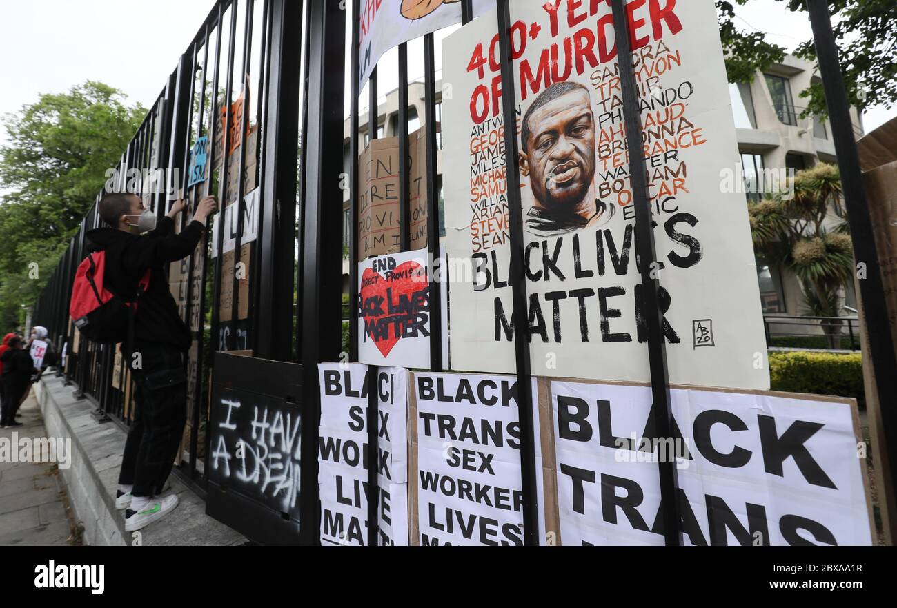 Die Menschen setzten ihre Zeichen auf ein Tor während einer Protestkundgebung vor der US-Botschaft in Dublin, in Erinnerung an George Floyd, der am 25. Mai in Polizeigewahrsam in der US-Stadt Minneapolis getötet wurde. Stockfoto