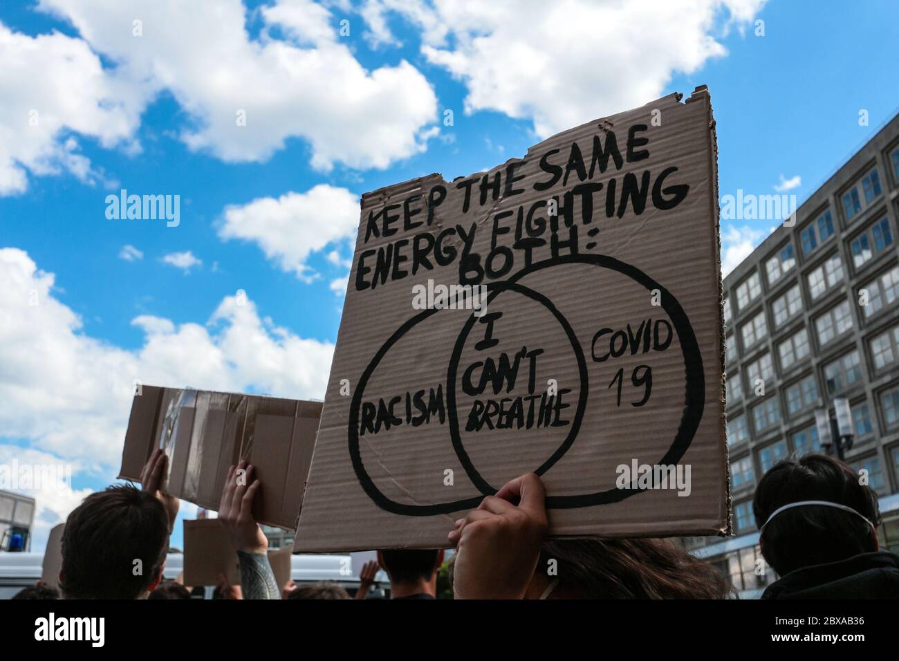 Protestschild liest Kreuzung 'Rassismus - ich kann nicht atmen - covid 19' bei einem Black Lives Matter Protest Alexanderplatz Berlin, Deutschland. Stockfoto