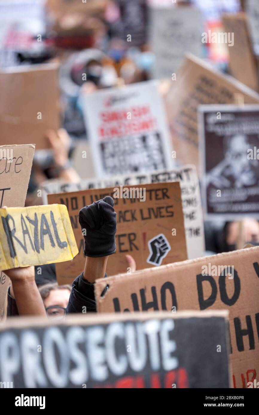 Eine aufgezogene, mit Handschuhen beklagt Faust ragt in einem Meer von selbstgemachten Kartonschildern hervor, bei der Black Lives Matter UK Protest, Parliament Square, London, England, UK Stockfoto