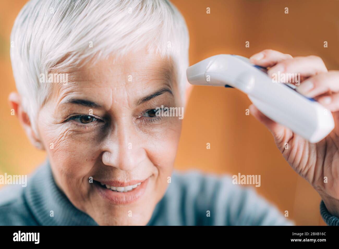 Körpertemperatur mit berührungslosen Thermometer messen Stockfoto