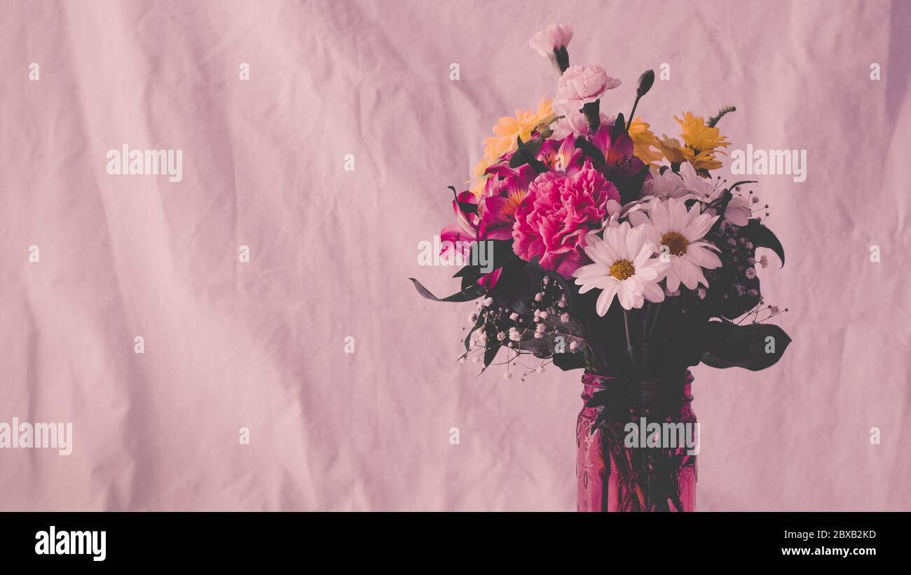 Blumenarrangement mit rosa verblichenen Tonalität Stockfoto