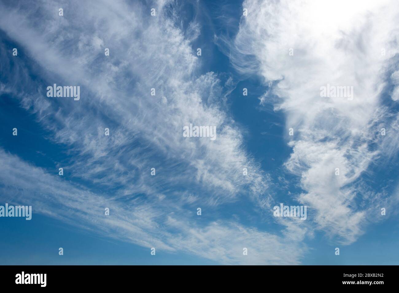 Ein strahlend blauer Himmel mit weißen, flüstigen Wolken Stockfoto