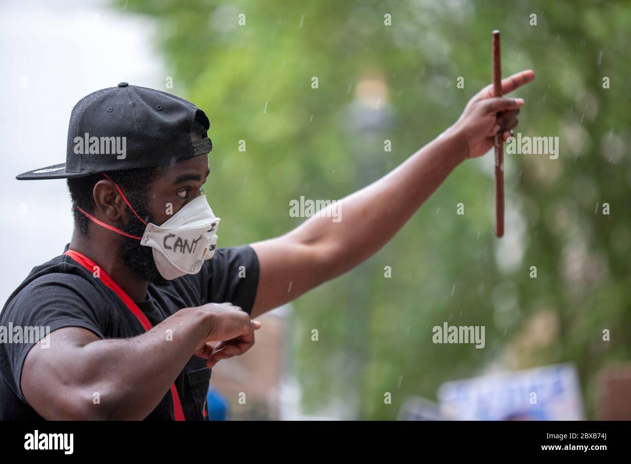 Mann, der eine Baseballmütze und Gesichtsmaske trägt, dirigiert ein musikalisches Kollektiv beim Protest von Black Lives Matter UK, Parliament Square, London UK Stockfoto