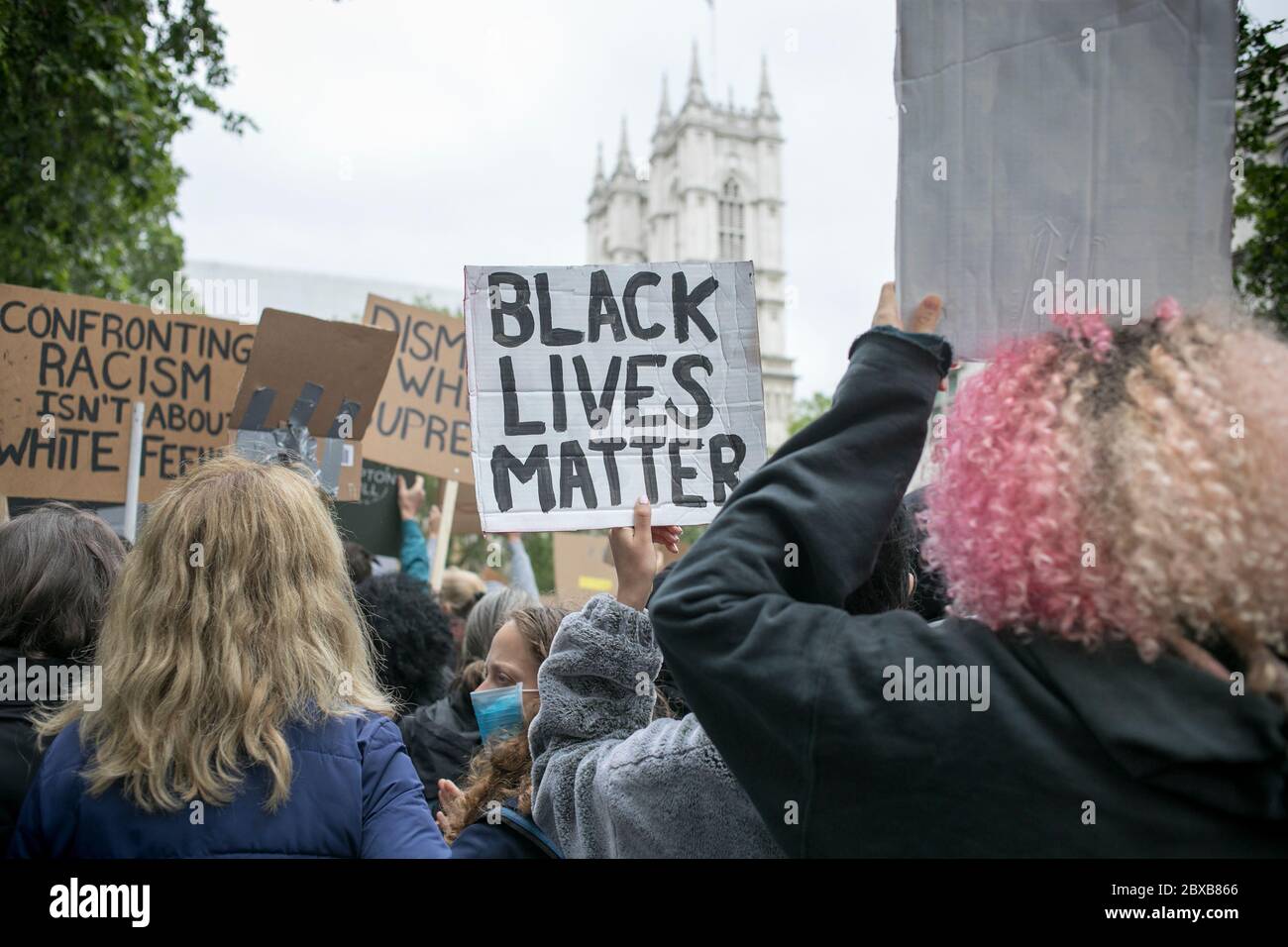 Protestierende halten Plakate gegen Westminster Abbey während der Kundgebung gegen systemischen Rassismus in Großbritannien im Zentrum von London. Stockfoto