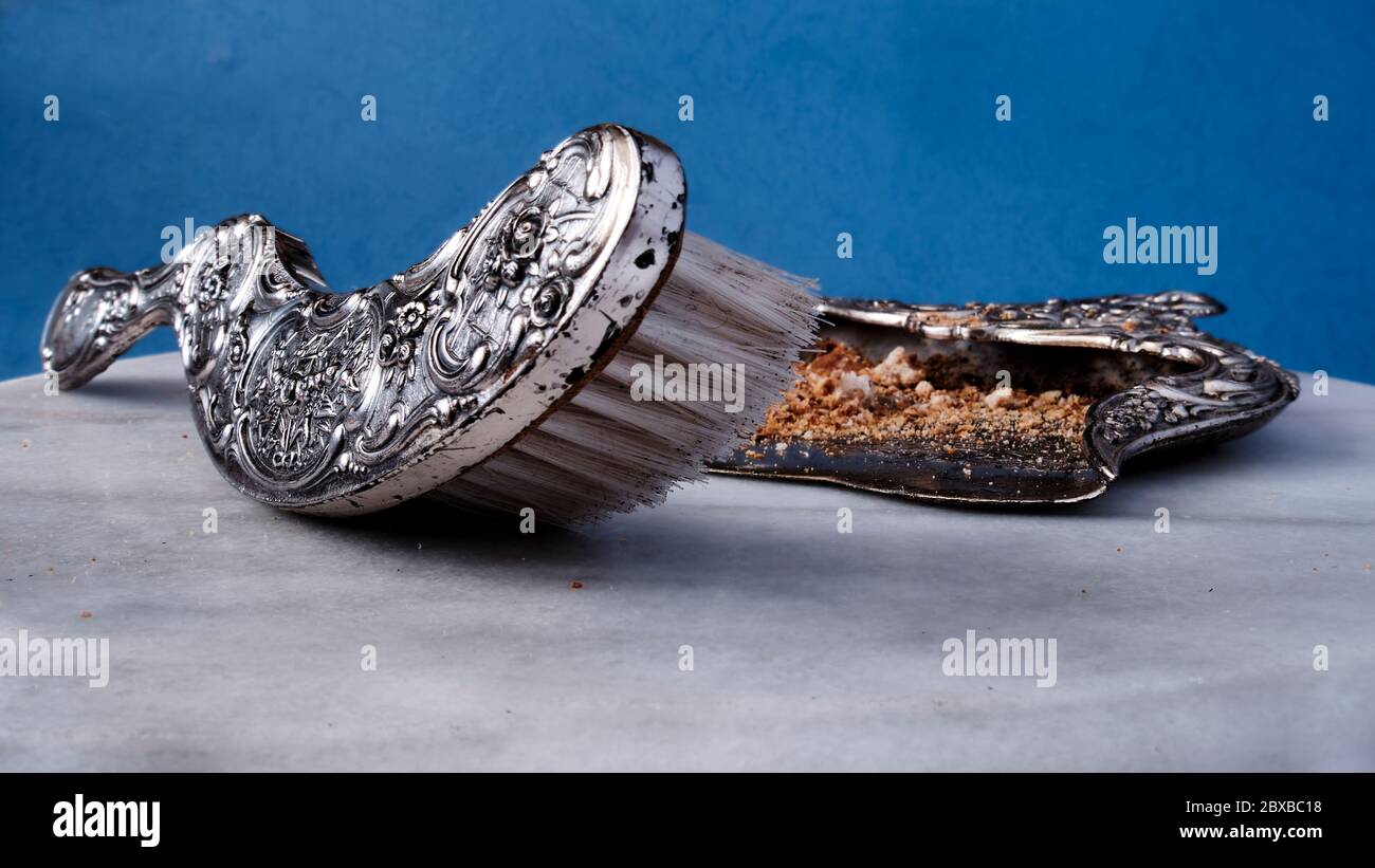 Ein verzierten Metall Whiskesen und Pfanne für die Reinigung der Tabelle von Krümeln zwischen Gängen. Stockfoto