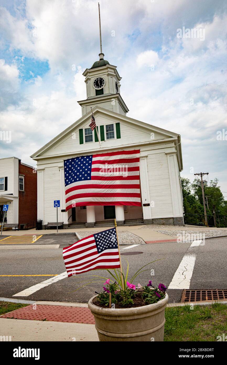 Das Barre, Massachusetts Town Hall mit einer sehr großen amerikanischen Flagge, die an der Vorderseite des Rathauses hängt. Stockfoto