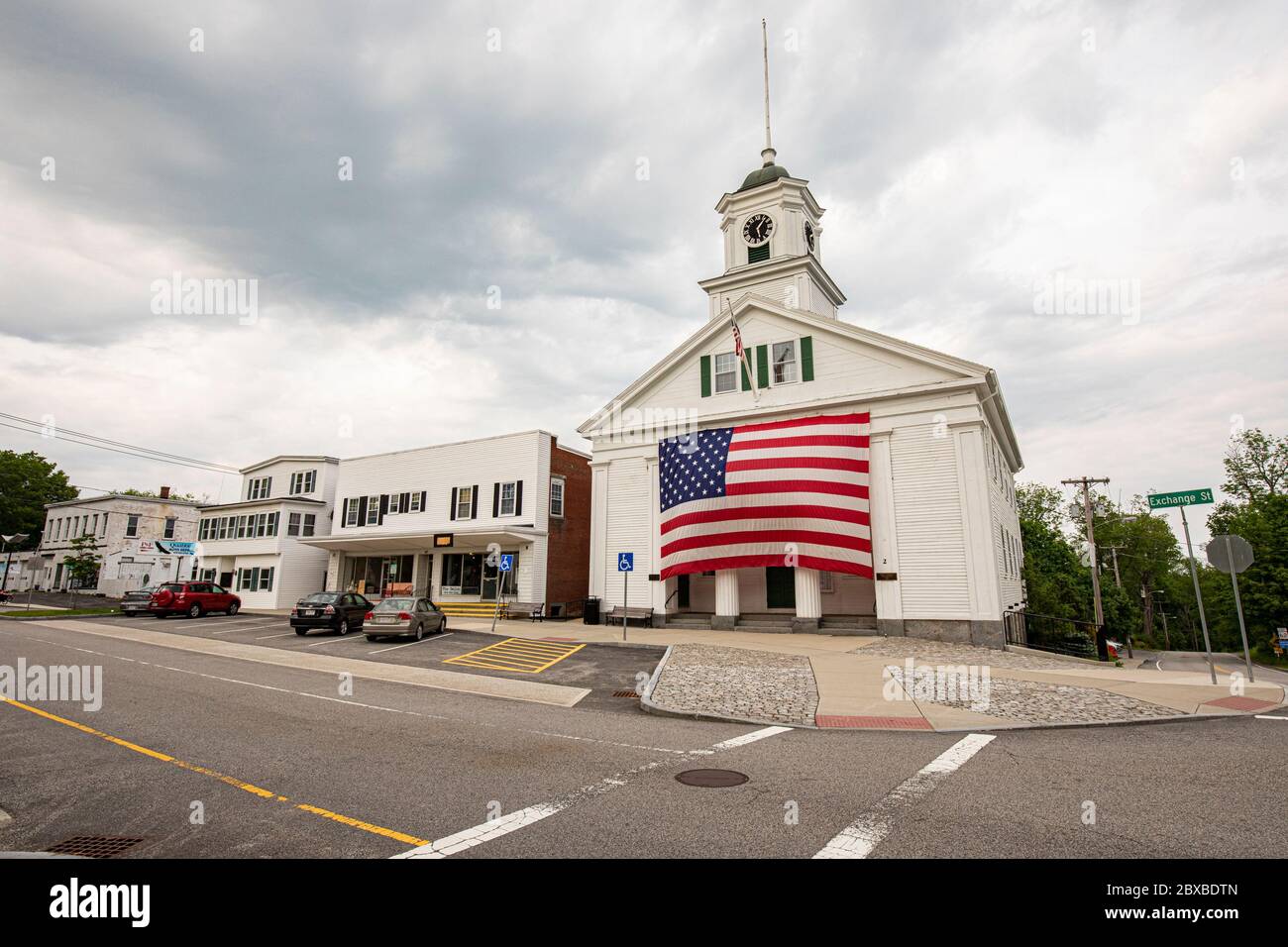 Das Barre, Massachusetts Town Hall mit einer sehr großen amerikanischen Flagge, die an der Vorderseite des Rathauses hängt. Stockfoto