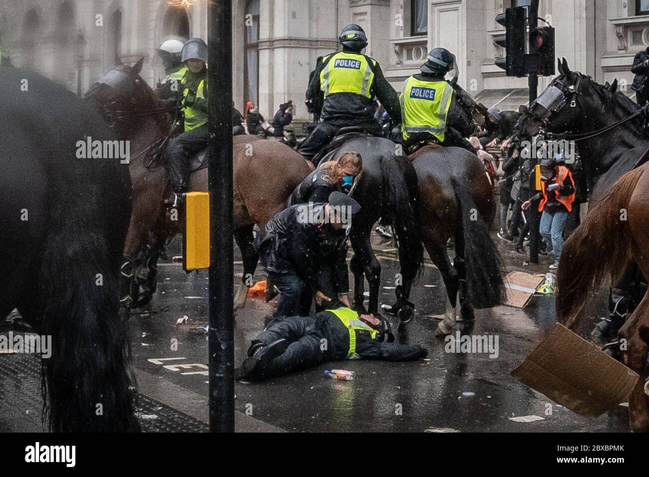 Ein Polizist liegt bewusstlos, nachdem er während der Zusammenstöße, die während der Proteste von Black Lives Matter in Westminster ausbrachen, von ihrem Pferd geworfen wurde. Fackeln, Flaschen und andere Trümmer wurden auf die Polizei geworfen, nachdem Tausende von Aktivisten und Unterstützern der Black Lives Matter auf dem Parliament Square eingepackt waren. London, Großbritannien. Stockfoto