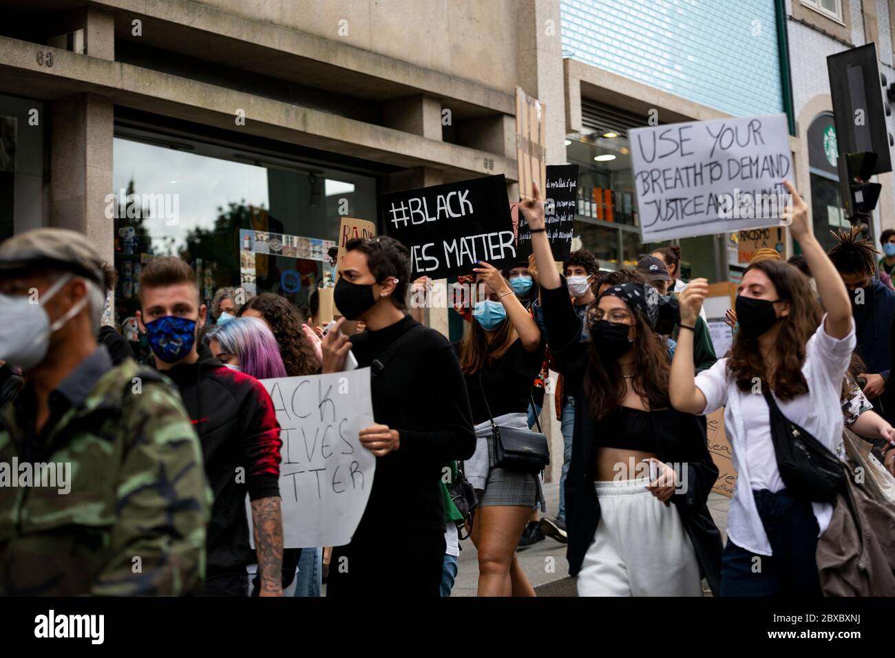 Menschen marschieren und halten Zeichen während der Demonstrationen gegen Rassismus und prekäre Arbeit am 6. juni 2020 in Porto. Stockfoto