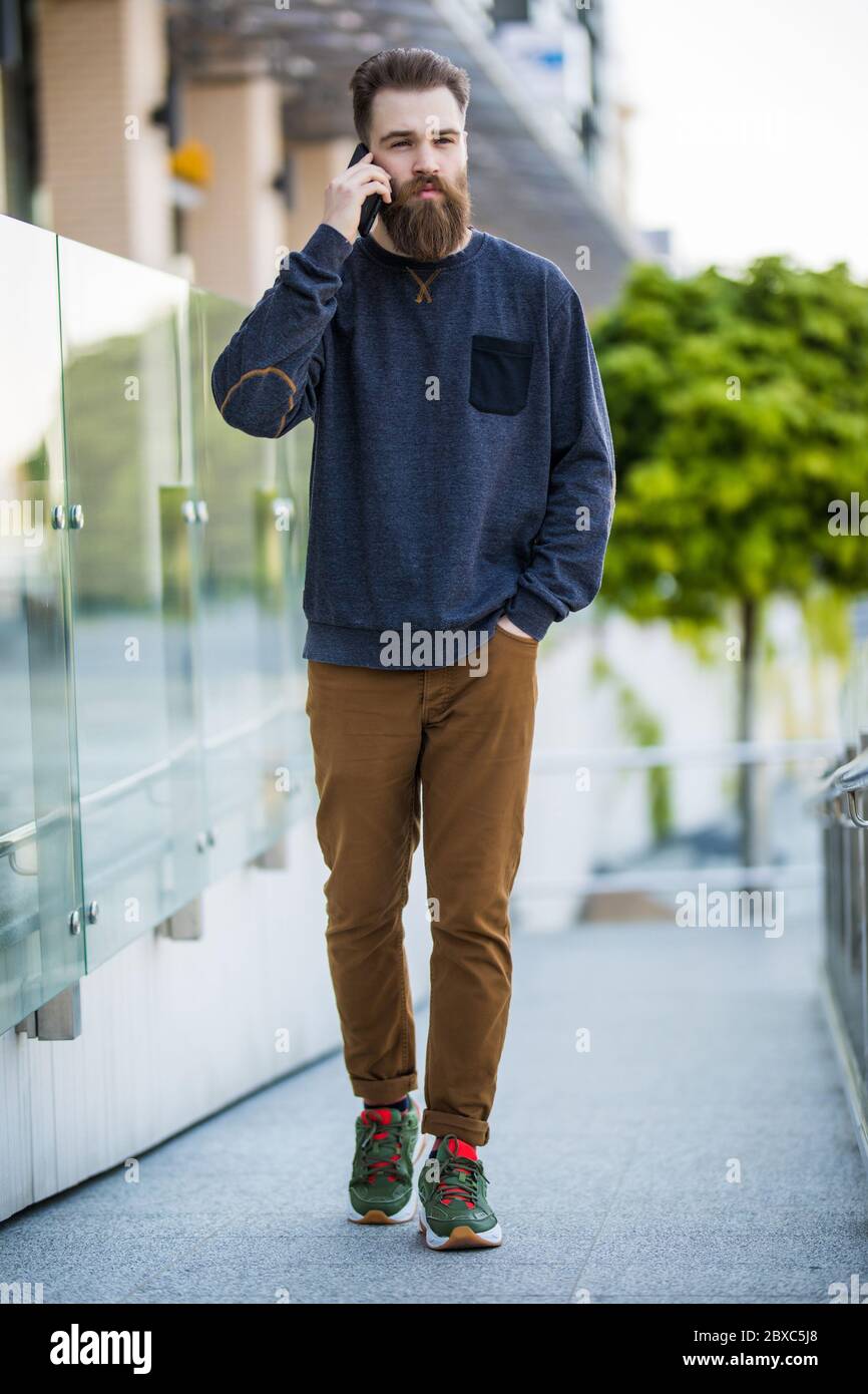 Schöner Mann mit Borsten im Freien. Mann mit lässigem Hemd halten Smartphone. Modernes Leben. Agiles Geschäft. Danke. Wie geht es Ihnen? Stockfoto