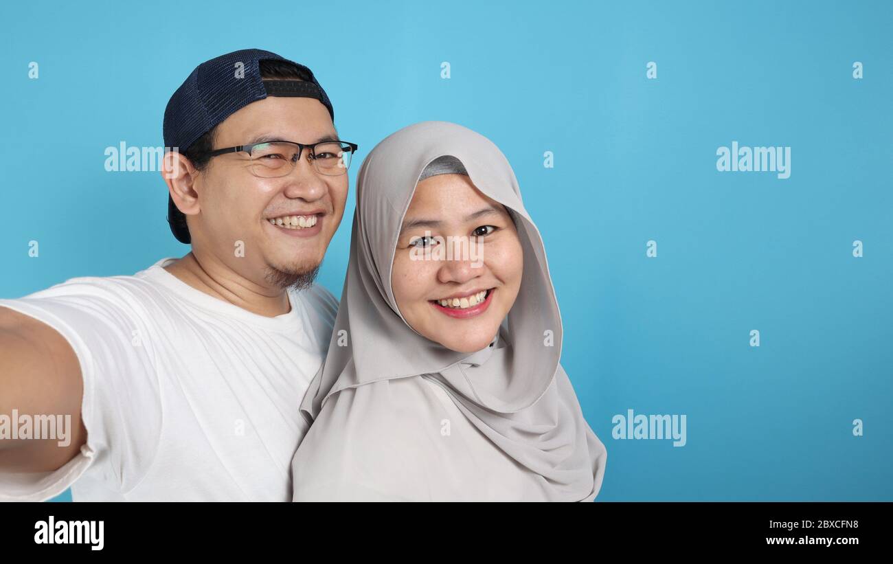Portait von glücklich asiatischen muslimischen Paar macht Selfie und lächelnd, Mann und Frau umarmt voller Liebe, Familienkonzept Stockfoto