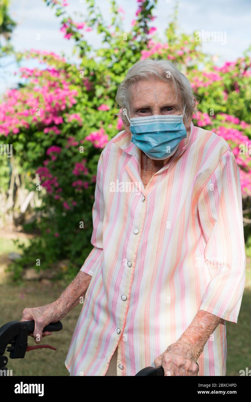 Ältere Dame mit Maske immer Bewegung gehen für einen Spaziergang im Garten Stockfoto