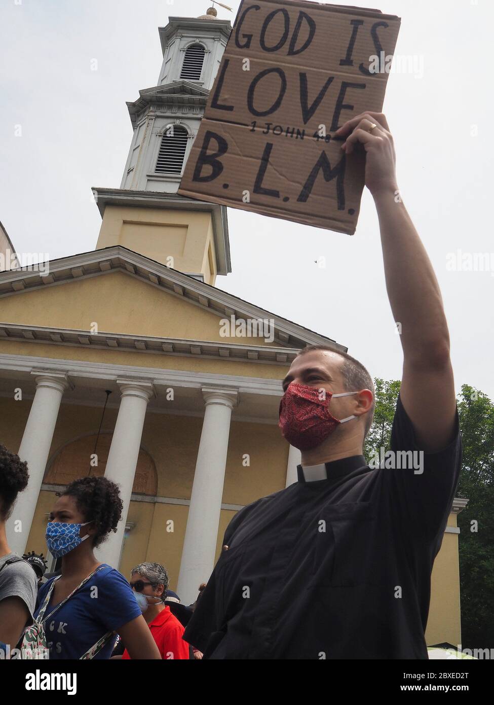 Washington, District of Columbia, USA. Juni 2020. Ein Mitglied des Klerus hält einen 'Gott ist Liebe' 'B.L.M.' (Black Lives Matter Schild vor der St. JohnÃs Episcopal Church in Lafayette Square, neu umbenannt in Black Lives Matter Plaza. Die historische Kirche war der Ort, wo Präsident Donald TrumpÃs Foto op Anfang der Woche. Kredit: Sue Dorfman/ZUMA Wire/Alamy Live News Stockfoto