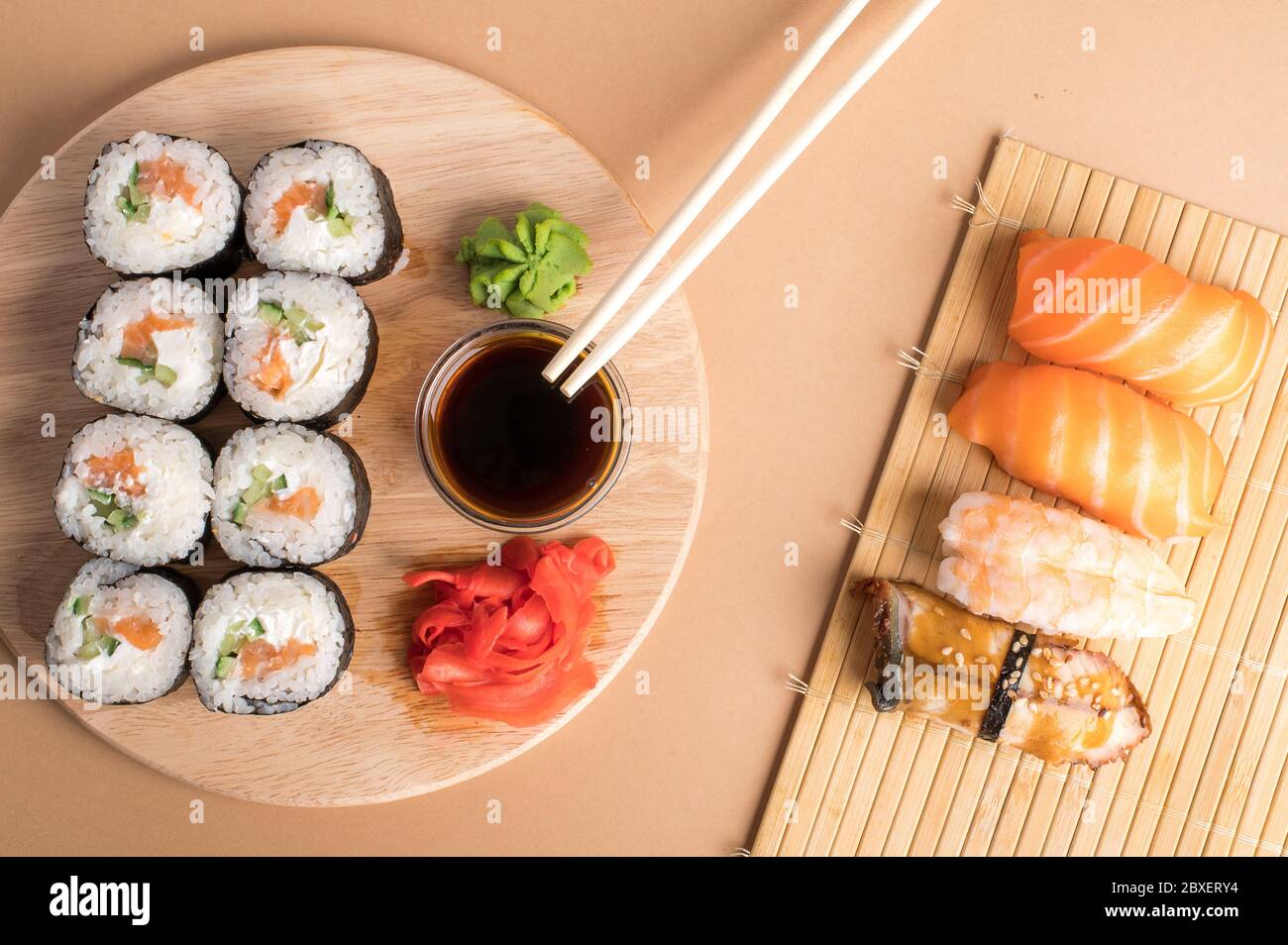 Sushi-Set Sashimi mit Lachs, Garnelen, Aal und Sushi-Brötchen auf Bambusmatte und Holzbrett serviert Stockfoto