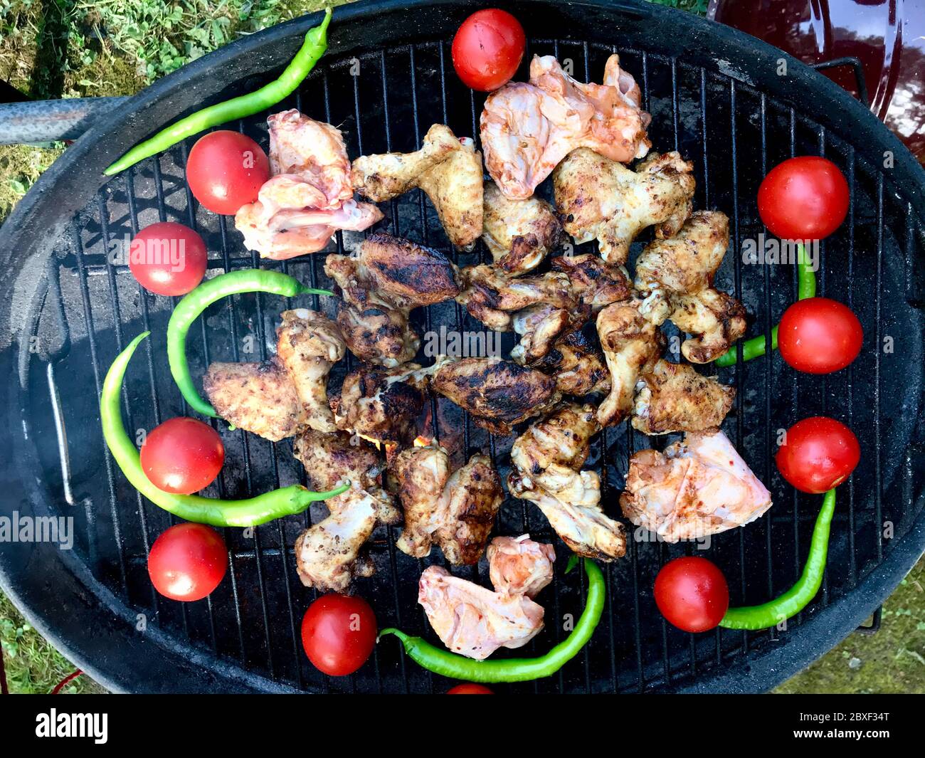 Türkischer Grill mit gegrilltem Chicken Wings Kebab, gerösteten Tomaten und grünen Chili-Paprika. Traditioneller Koch. Stockfoto