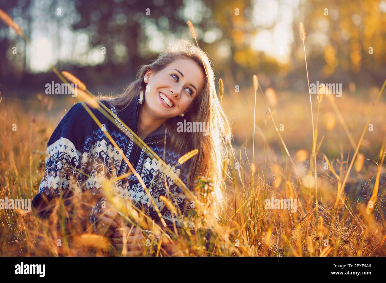 Lächelnd blaue Augen Mädchen in einem Feld. Warmes Licht bei Sonnenuntergang Stockfoto