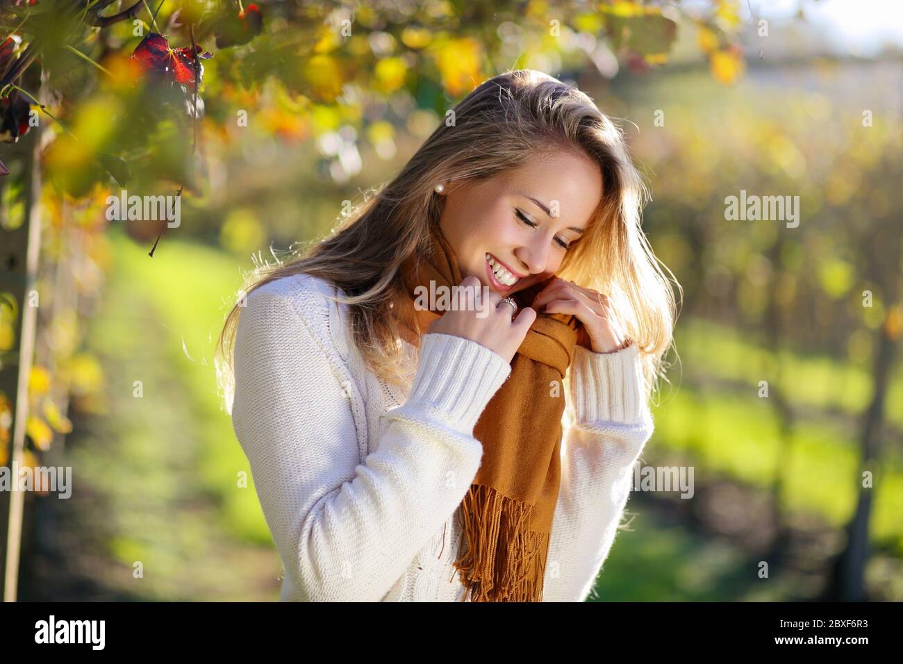 Lächelnde Frau genießt Herbstsonne auf dem Land Stockfoto