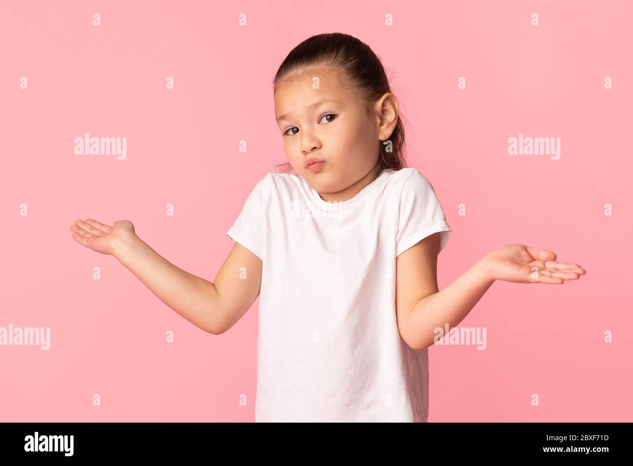 Verwirrt verwirrt verwirrt asiatisch Mädchen zucken im Studio Stockfoto