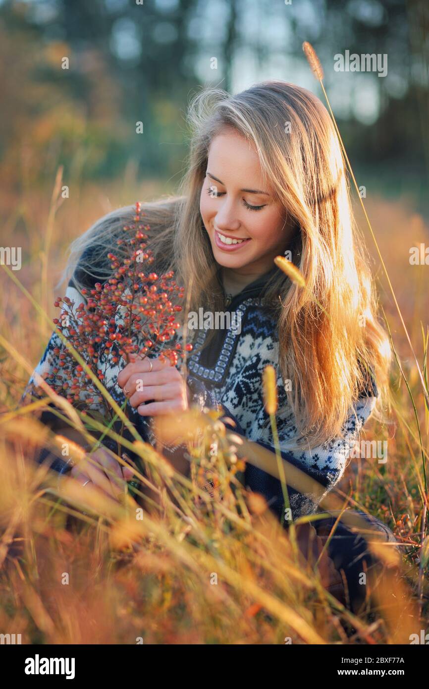 Lächelnde junge Frau in einem Feld. Warmes Licht bei Sonnenuntergang Stockfoto