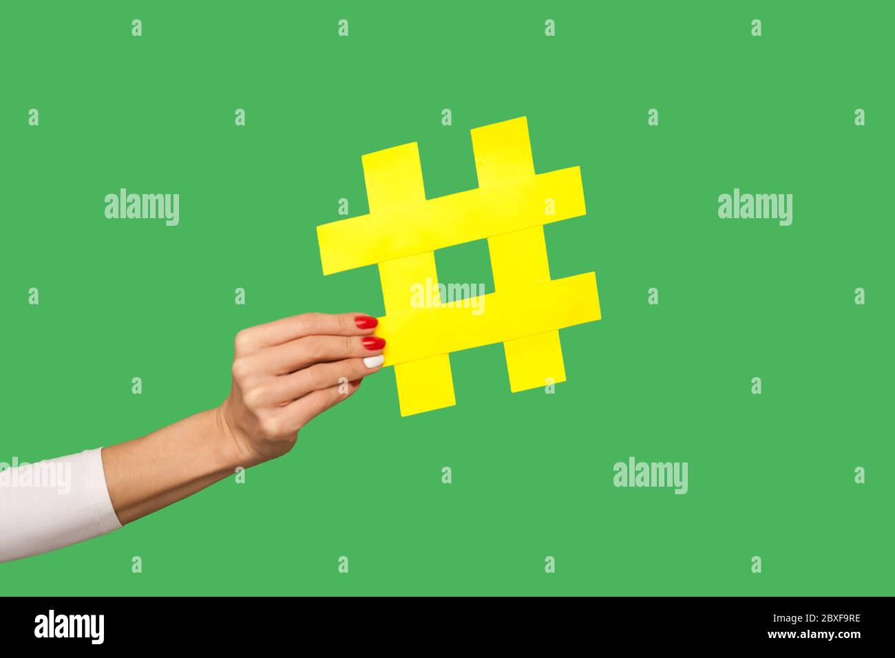 Blog-Kommentare, Social Media Trends. Nahaufnahme der Frau Hand mit großen gelben Hashtag Zeichen, Tagging berühmten Internet-Post, Teilen viralen Inhalts, popula Stockfoto
