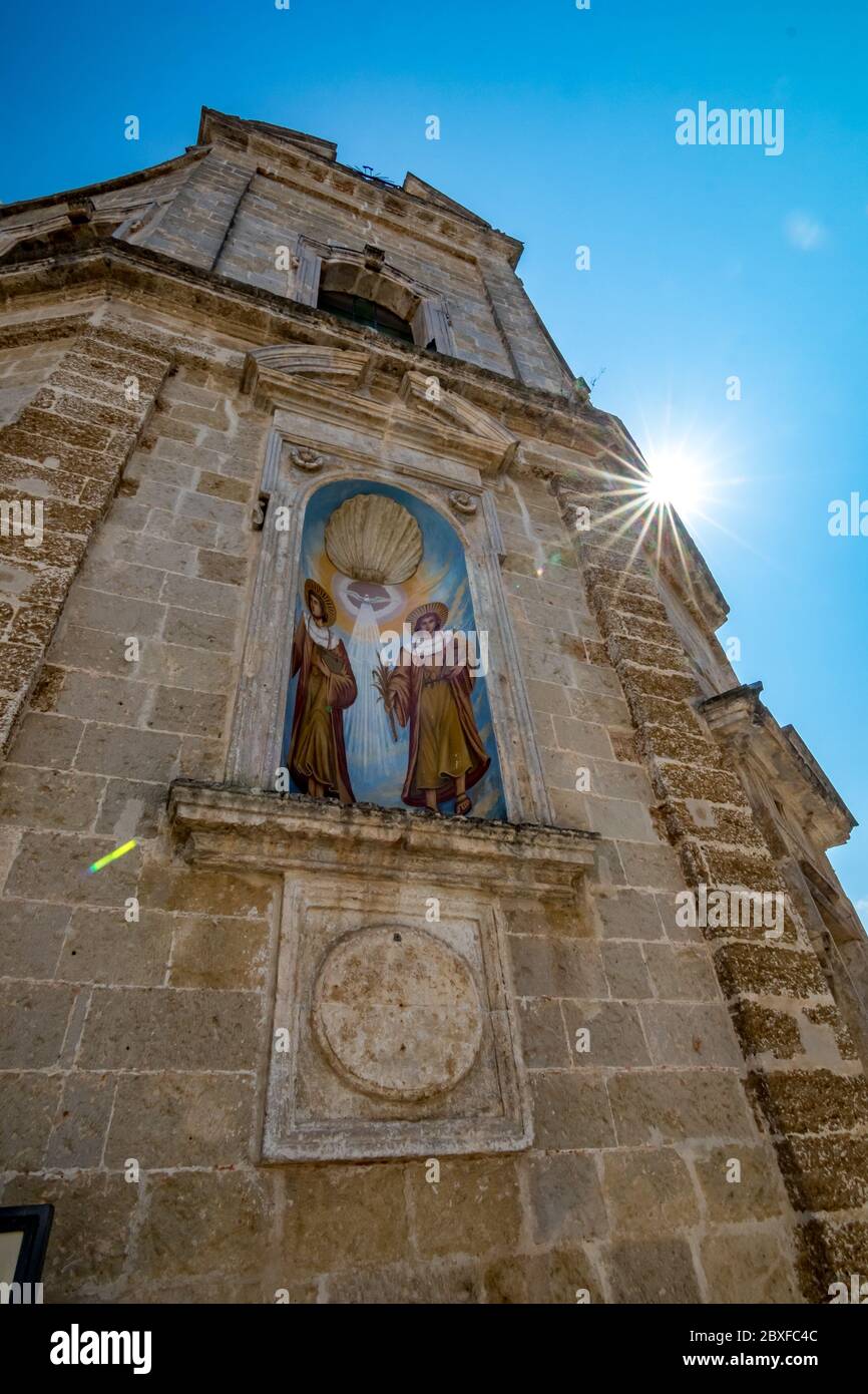 Niedrige Winkel Straßenansicht der Kirche von SS. Cosma e Damiano. Mesagne. Apulien. Italien. Schöner Sonnenlichtbeugungseffekt in der oberen rechten Ecke des Rahmens, vertikaler Hochformat-Modus Stockfoto