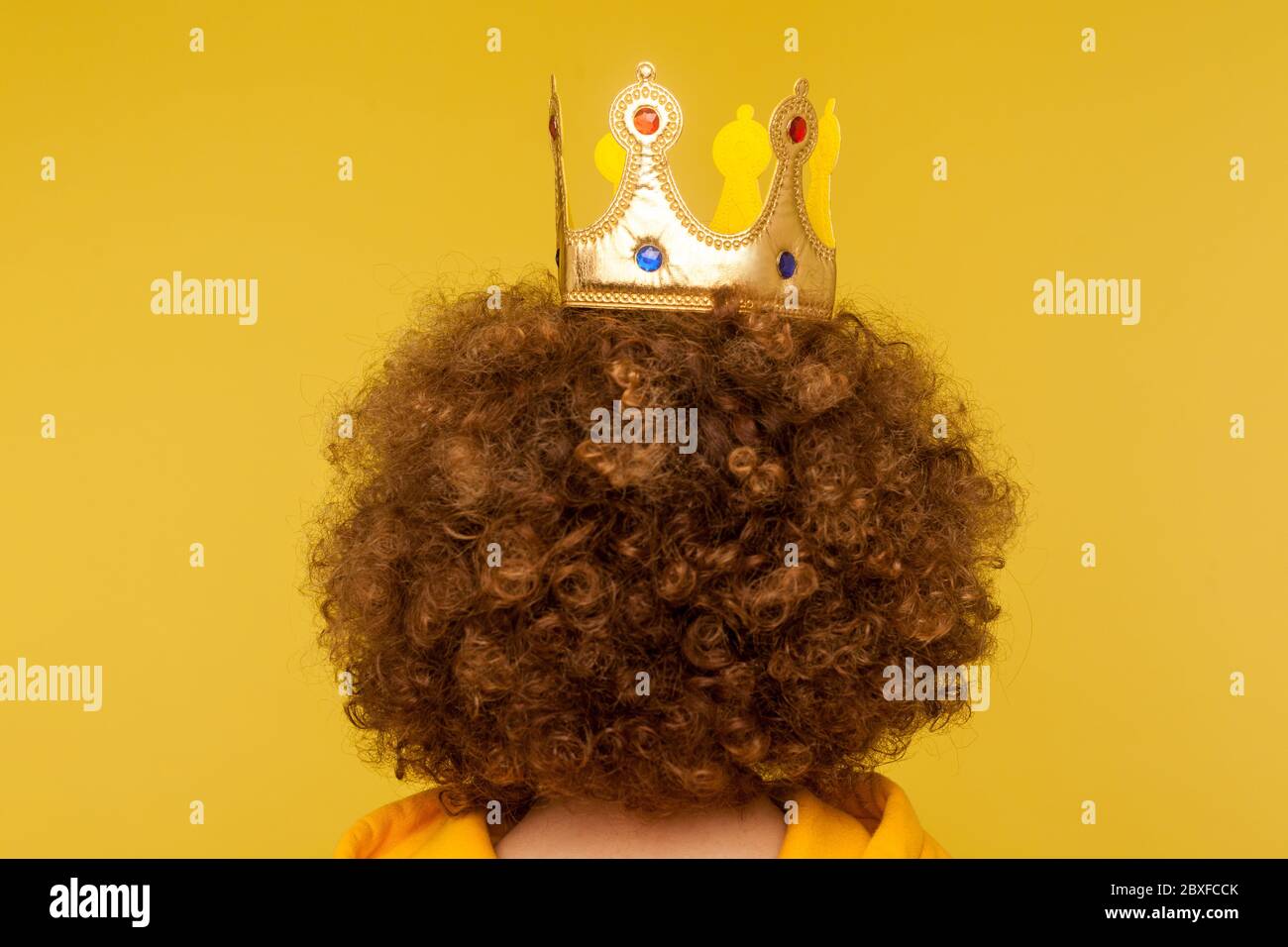 Nahaufnahme des Kopfes mit goldener Krone auf lockigen Afro-Frisur, Konzept der überlegenen privilegierten Status, große Ambitionen und Träume zu Führer in der Leitung zu werden. In Stockfoto