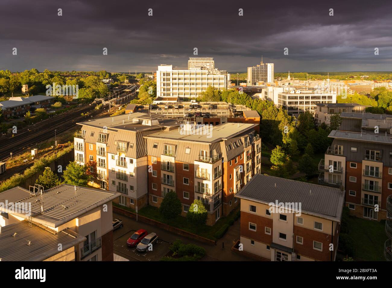 Eine Luftaufnahme von einem stürmischen Himmel mit Regenwolken während des Sonnenuntergangs mit dramatischer Beleuchtung über Basingstoke Stadtzentrum mit Wohnungen und Büros, Großbritannien Stockfoto