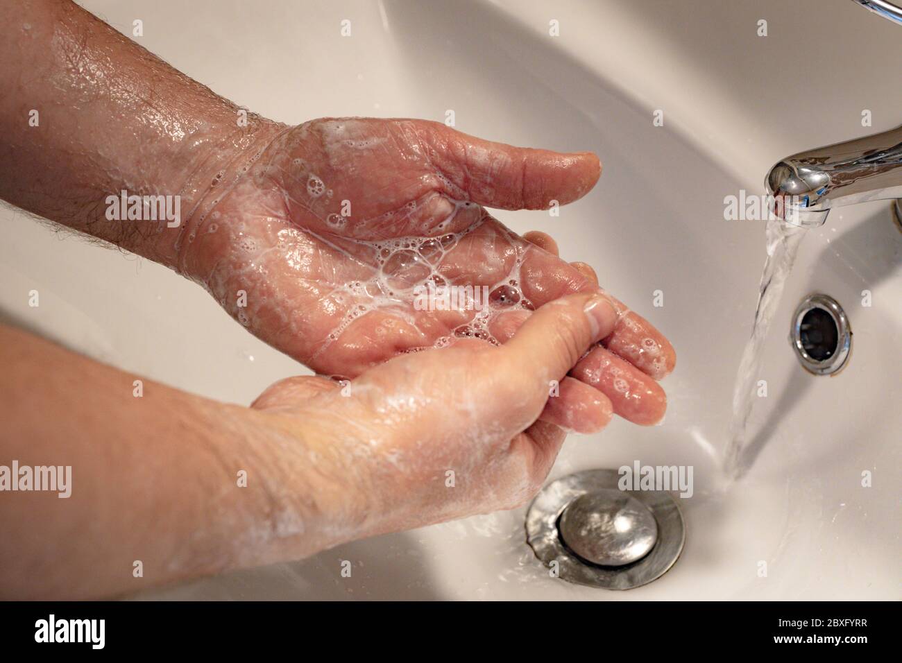 Seifenhände unter fließendem Wasser, Körperhygiene, Händewaschen, Entfernen von Viren und Bakterien, Grundschutz gegen Viren und Bakterien Stockfoto