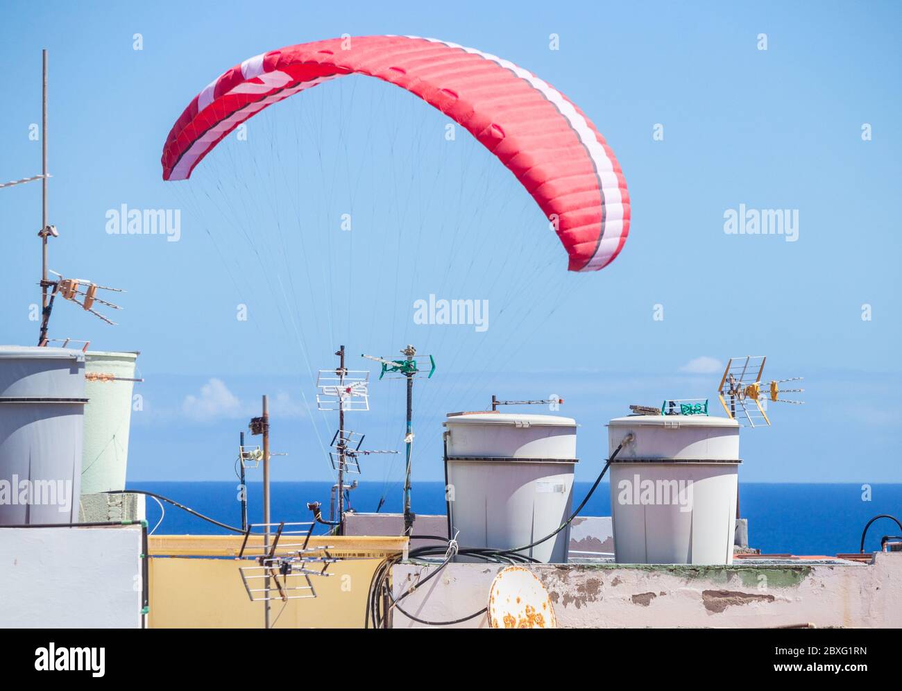 Las Palmas, Gran Canaria, Kanarische Inseln, Spanien. Juni 2020. Ein Paragleiter, der über Dächern an der Nordküste Gran Canarias fliegt. Auf den Kanarischen Inseln und in vielen anderen Regionen Spaniens werden die Beschränkungen weiter gelockert, wenn sie am Montag, den 8. Juni, in die Phase 3 der Lockdown Lockdown-Lockerung eintreten. Quelle: Alan Dawson/Alamy Live News Stockfoto