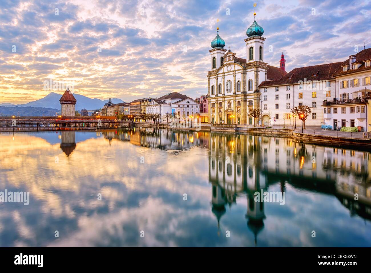 Luzerner Altstadt, Schweiz, Blick auf die Reuss, Kapellbrücke und Jesuitenkirche bei dramatischem Sonnenaufgang Stockfoto