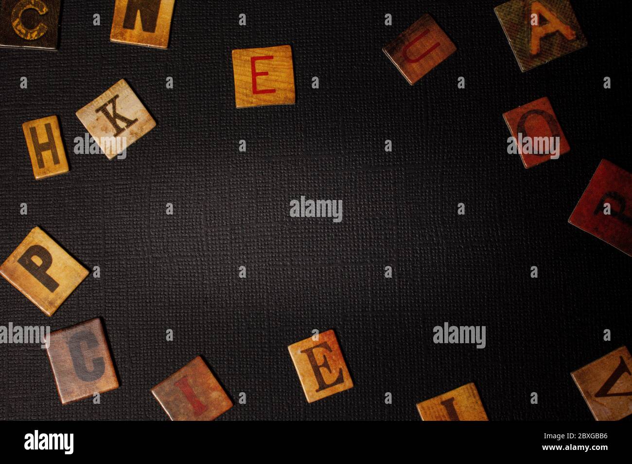 Zufällige Buchstaben des Alphabets auf schwarzem Hintergrund mit Kopierraum Stockfoto