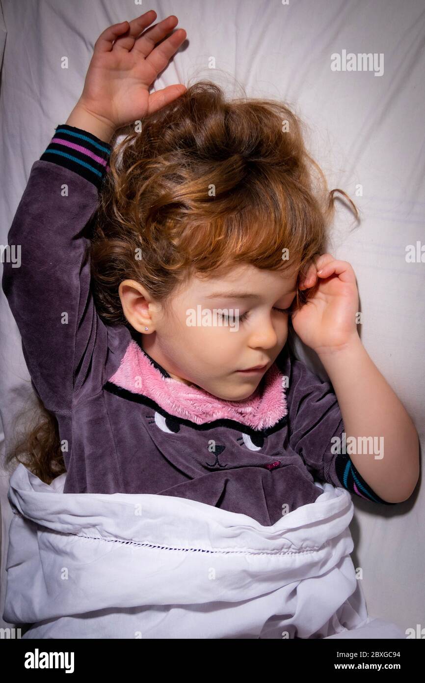 Blick von oben auf ein Mädchen, das im Bett schläft Stockfoto
