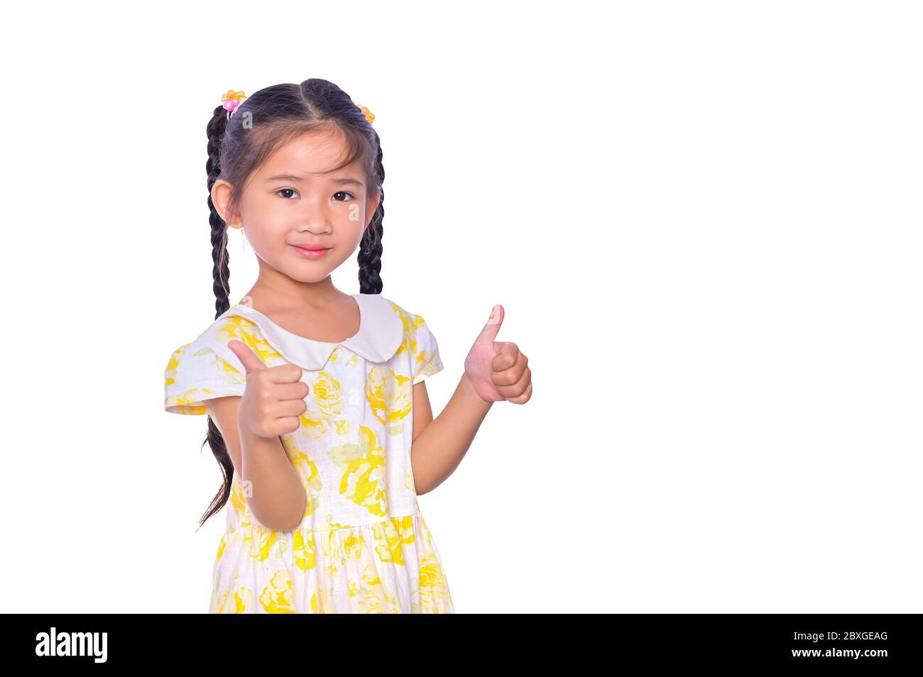 Liebenswert und fröhlich asiatischen Kind geben Daumen nach oben und Lächeln Gesicht isoliert über weißem Hintergrund Stockfoto
