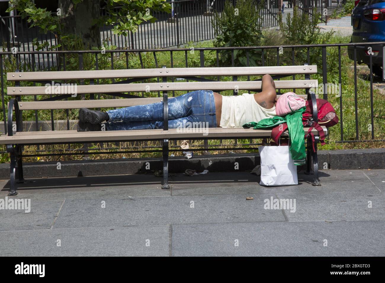 Mann macht ein Nickerchen auf einer Bank am Cadman Plaza in Brooklyn, New York. Stockfoto