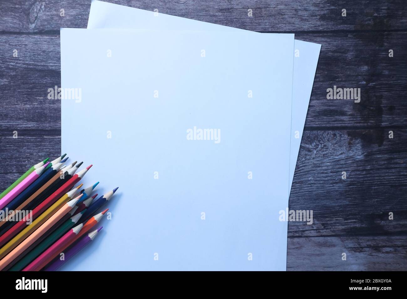 Leeres Papier mit Farbstiften auf Holzhintergrund Stockfoto