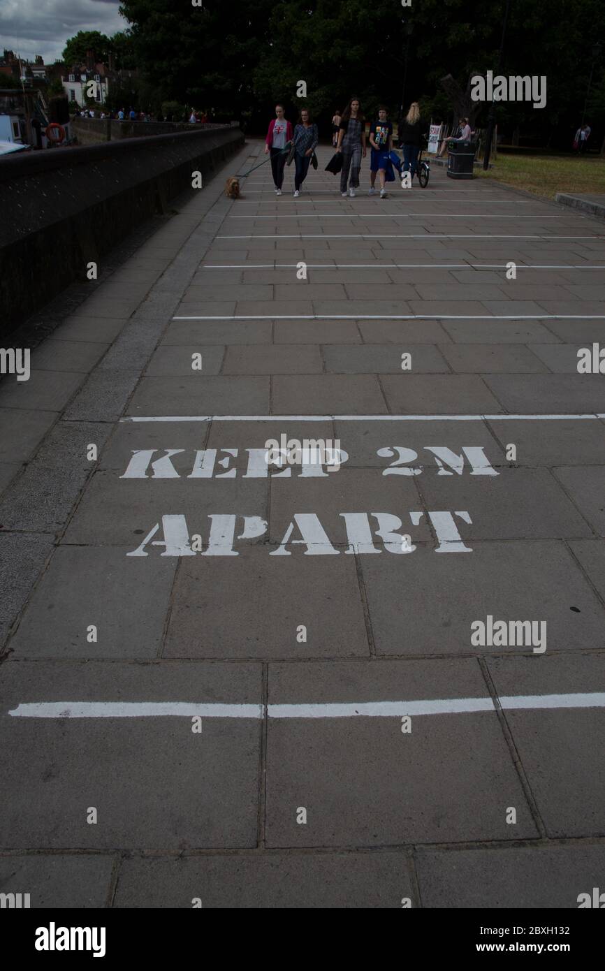 Schild auf dem Bürgersteig erinnert die Menschen zwei Meter auseinander während der Corona Pandemie, Hammersmith West London UK bleiben Stockfoto